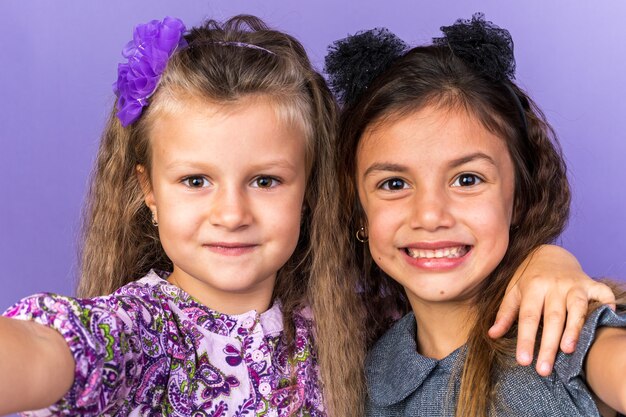 sorridenti bambine graziose isolate sulla parete viola con copia spazio copy