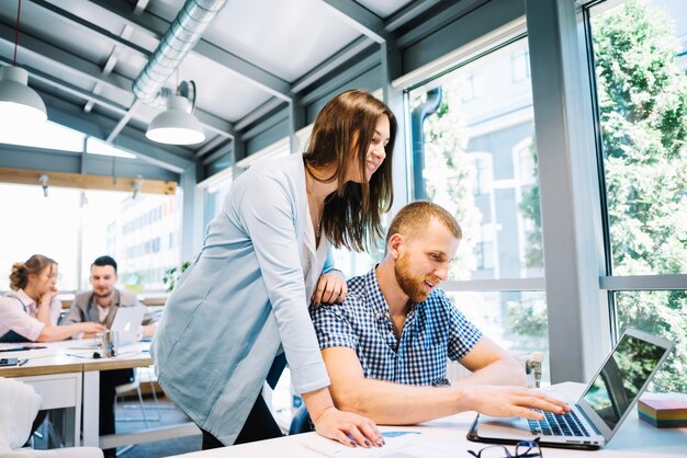 Sorridere uomo e donna che lavorano al computer portatile