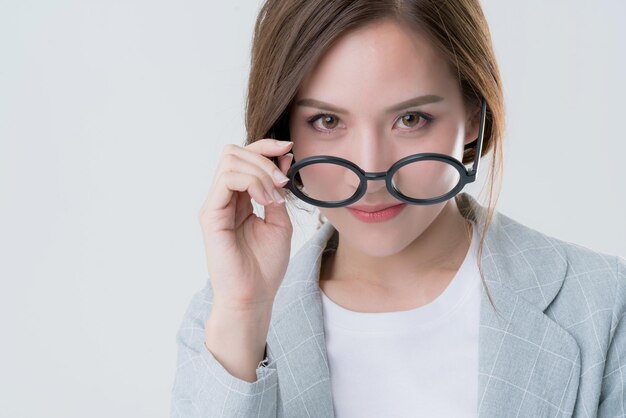 Sorriso di carriera creativa della bella donna asiatica attraente degli occhiali e contatto visivo alla macchina fotografica con fiducioso e gioioso