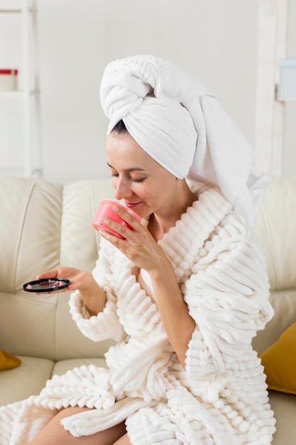 Spa a casa donna che sente l'odore di una crema rosa