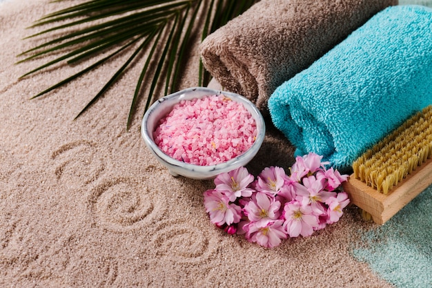 Spa Concept. Closeup di bellissimi prodotti Spa - sale da bagno, asciugamani e fiori. Orizzontale.