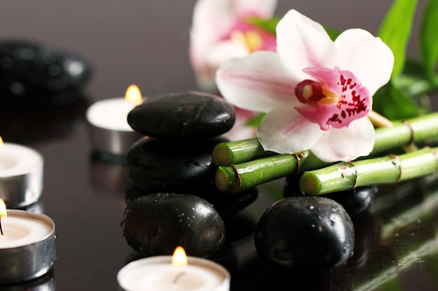 Spa e benessere, massaggio pietre e fiori sulla tovaglia in legno