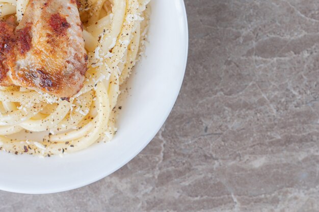 Spaghetti al sugo di pomodoro in una ciotola, sulla superficie di marmo.