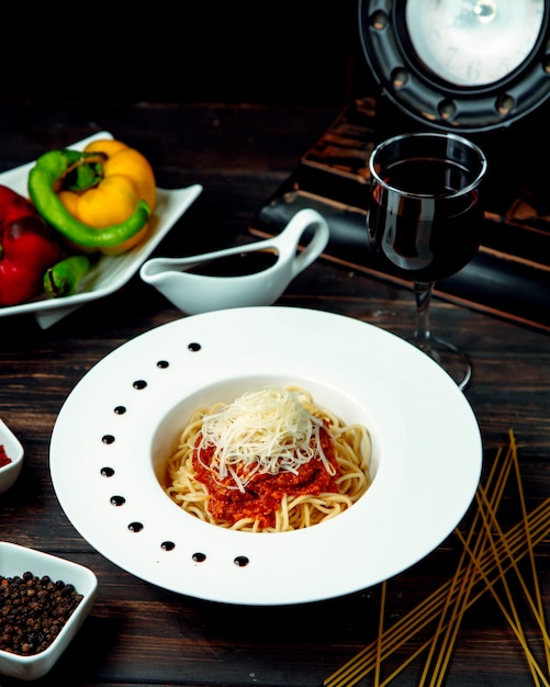 Spaghetti alla bolognese con vino rosso sul tavolo