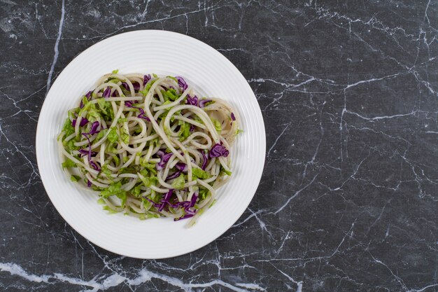 Spaghetti appena fatti con salsa di verdure sulla zolla bianca.