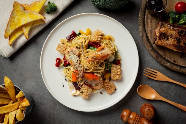 Spaghetti con frutti di mare misti piccanti su fondo scuro