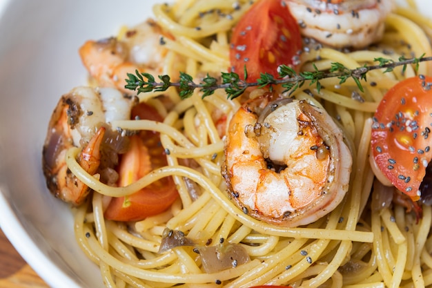 Spaghetti con gamberi fritti e pomodori freschi.