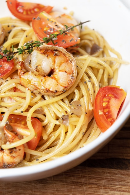 Spaghetti con gamberi fritti e pomodori freschi.