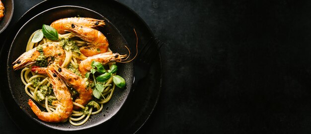 Spaghetti con pesto e gamberi serviti sul piatto