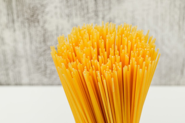 Spaghetti crudi su bianco e sul fondo di lerciume, vista dell'angolo alto.