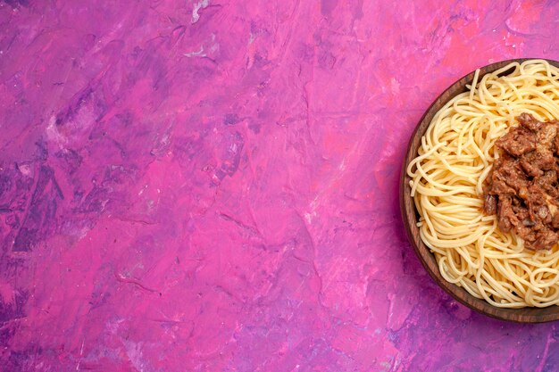 Spaghetti cucinati vista dall'alto con carne macinata su pasta rosa da tavola