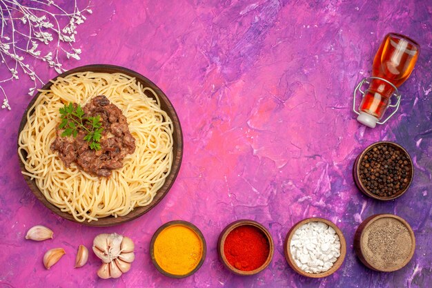 Spaghetti cucinati vista dall'alto con carne macinata su un piatto di pasta condimento per pasta rosa