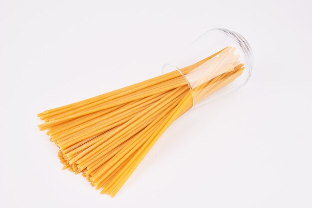 Spaghetti da una tazza di vetro.