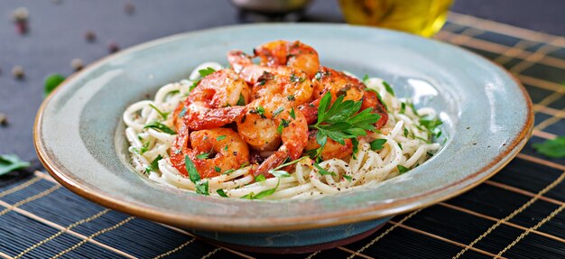 Spaghetti di pasta con gamberi, pomodoro e prezzemolo tritato. Cibo salutare. Pasto italiano.