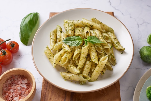 Spaghetti di pasta con zucchine, basilico, panna e formaggio sulla tavola di pietra nera.