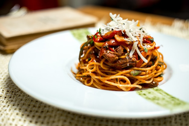 Spaghetti di vista laterale con carne e formaggio grattugiato