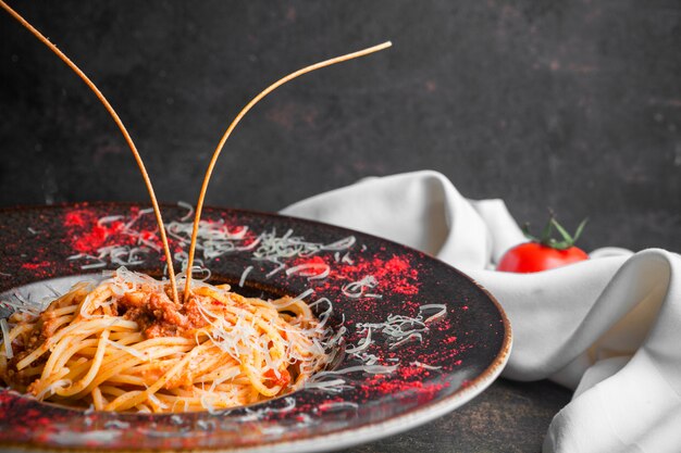 Spaghetti di vista laterale con carne tritata in piatto rotondo