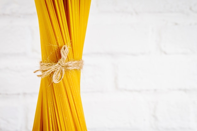 Spaghetti gustosi freschi freschi italiani sul tavolo della cucina sullo sfondo della cucina. Cottura o concetto di alimenti sani. Avvicinamento.