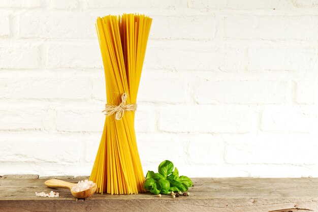 Spaghetti gustosi freschi freschi italiani sul tavolo della cucina sullo sfondo della cucina. Cottura o concetto di alimenti sani.