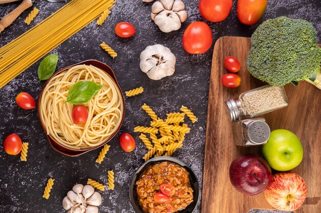 Spaghetti saltati in un piatto grigio con pomodori e basilico