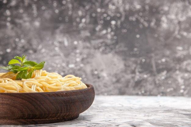 Spaghetti saporiti di vista frontale con la foglia verde sulla pasta bianca del piatto del pasto della pasta della tavola