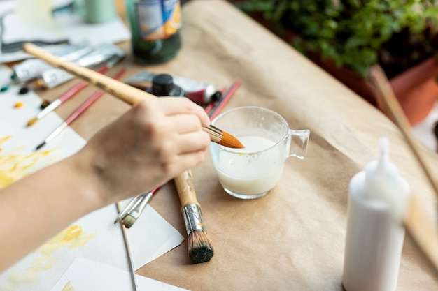 Spazzola di pittura della tenuta della mano dell'angolo alto