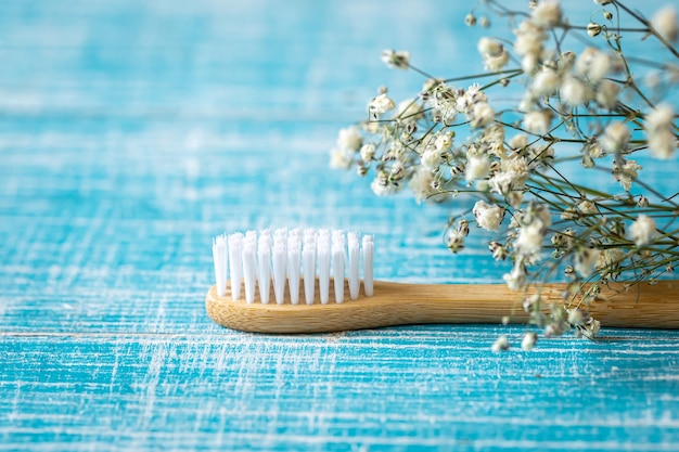 Spazzolino da denti in bambù ecologico naturale su uno spazio di copia di sfondo blu