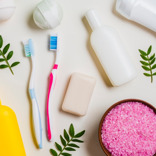 spazzolino da denti; sapone; bomba da bagno; sale rosa e prodotti cosmetici su sfondo bianco