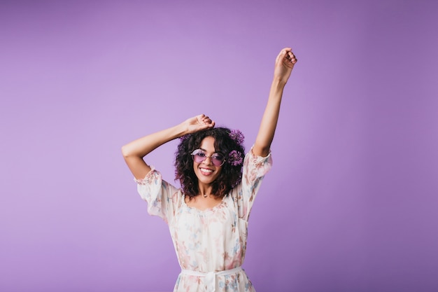 Spettacolare ragazza in abito carino ballando con il sorriso. Tiro al coperto di adorabile modello femminile africano agghiacciante mentre posa.