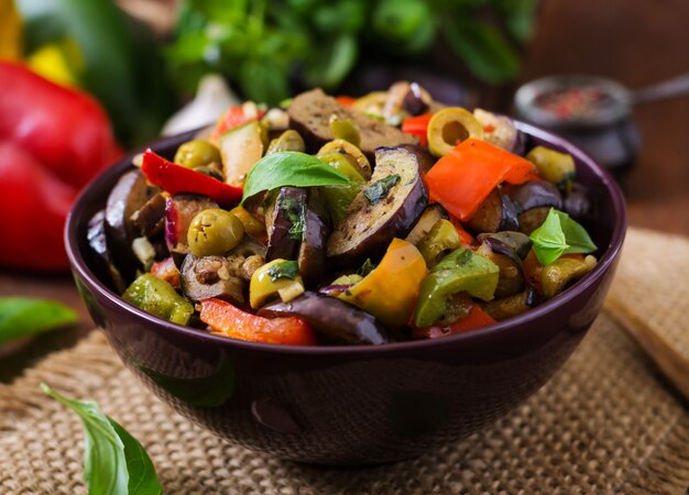 Spezzatino piccante speziato di melanzane, peperoni, olive e capperi con foglie di basilico.