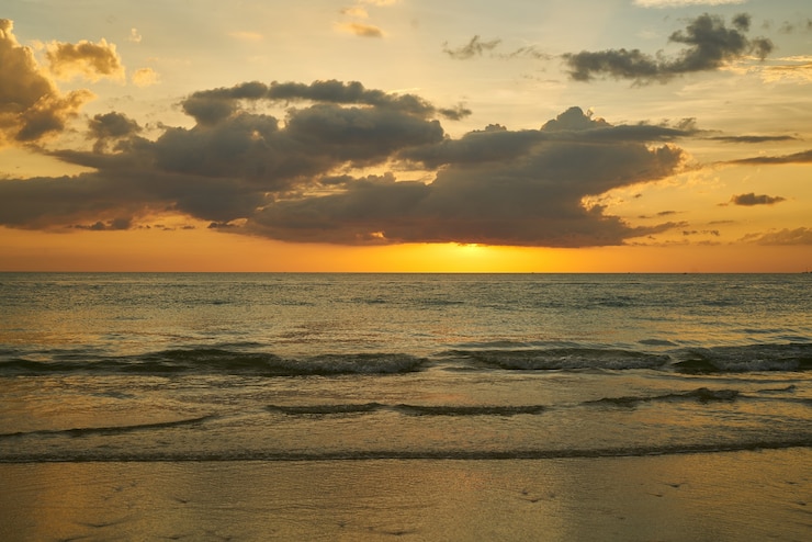 Foto gratuito spiaggia al tramonto con le nuvole