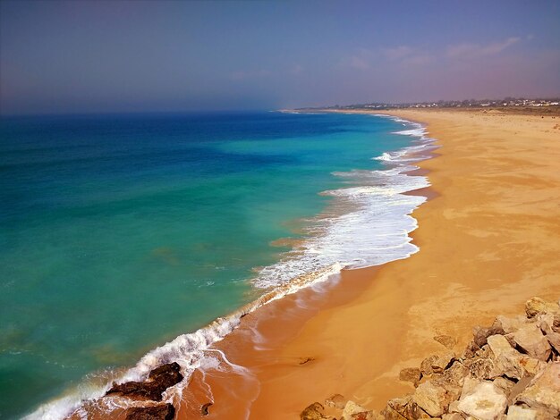 Spiaggia circondata dal mare sotto la luce del sole a Cadice, Spagna