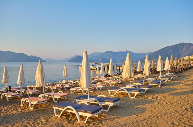 Spiaggia di sabbia senza persone e con lettini ombrelloni palme Marmaris