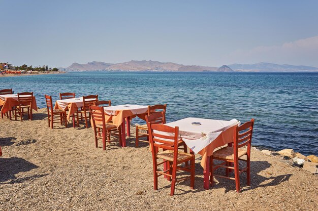 Spiaggia greca con tavoli e sedie blu tradizionali