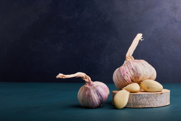 Spicchi d'aglio su un pezzo di legno.