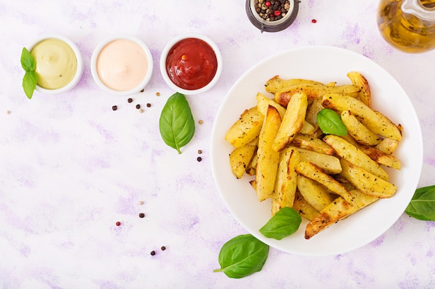 Spicchi di patate Ruddy Baked con erbe. Disteso. Vista dall'alto.