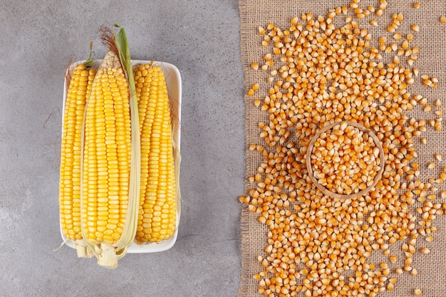 Spighe di mais fresche con fagioli di mais non cotti su una tela di sacco