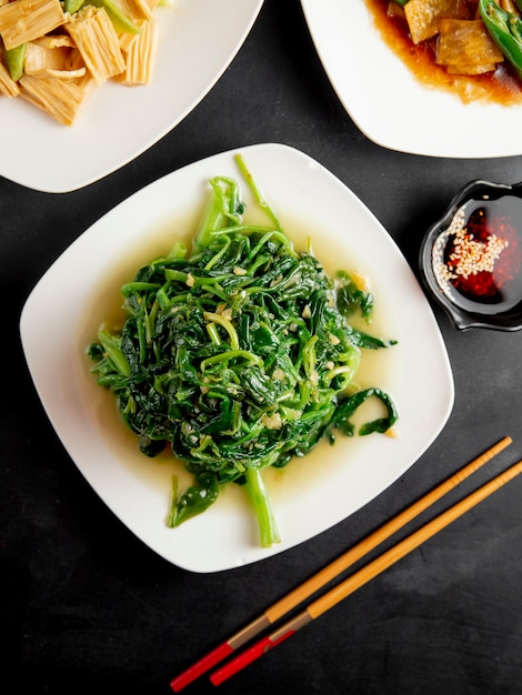 spinaci fritti e salsa di soia sul tavolo