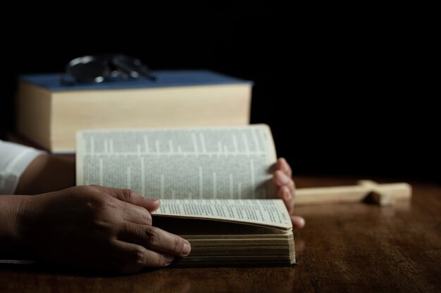 Spiritualità e religione, Mani giunte in preghiera su una Sacra Bibbia in chiesa