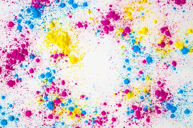 Splatter di giallo; polvere di colore rosa e blu holi su sfondo bianco