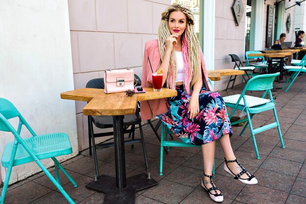 Splendida donna abbastanza elegante in posa sulla terrazza al caffè della città