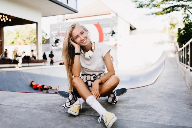 Splendida donna in calzini bianchi carini in posa con lo skateboard.