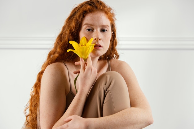 Splendida donna in posa con fiore di primavera