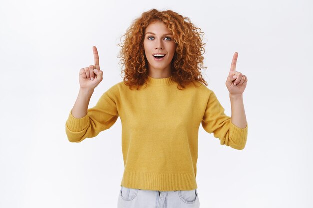 Splendida donna rossa sorridente con i capelli ricci rivolti verso l'alto