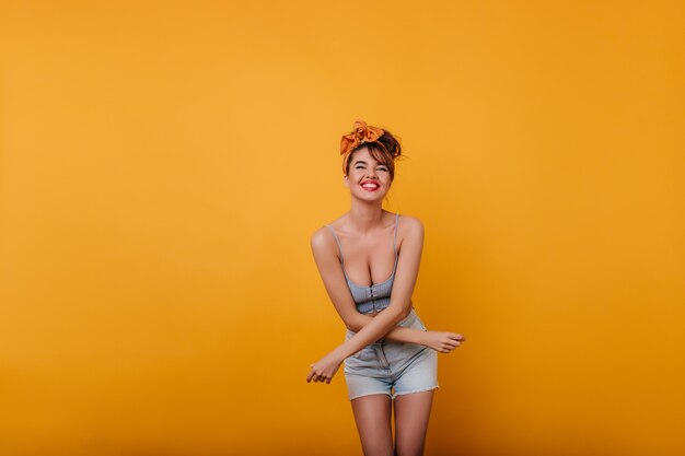 Splendida giovane donna con un sorriso sincero che gode del servizio fotografico in abiti vintage