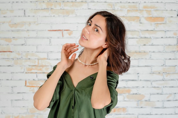 Splendida ragazza che allunga i capelli e guarda la telecamera