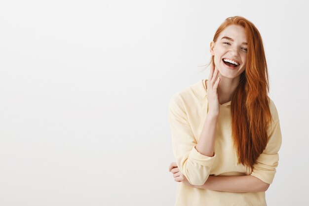 Splendida ragazza rossa che ride dalla felicità, guardando ottimista