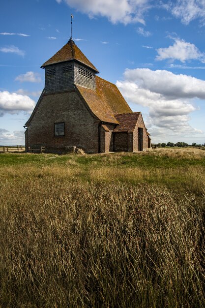 Splendida ripresa di una vecchia chiesa e di un campo erboso nel Regno Unito in una giornata nuvolosa