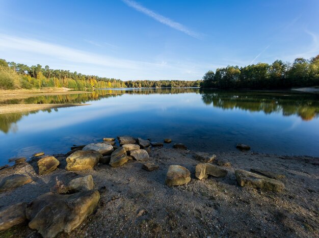 Splendido scenario di rocce vicino a un lago tranquillo sotto un cielo blu