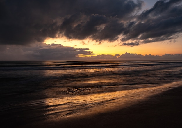 Splendido scenario di un mare ondoso sotto un cielo nuvoloso all'alba